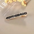 Sparkling gold hair clip with black and clear rhinestones on a magazine background - Rectangular Press Clip / Black