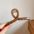 Haarklammer in Bernsteinbraun mit großem gedrehtem Design in der Hand gehalten - Große Kaffeebraune Haarklammer 13cm