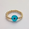 Macro detail of elastic beaded ring with golden spheres and blue Evil Eye charm - Size 7 (Elastic) / Light Blue
