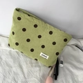 Macro view of green corduroy cosmetic bag with brown polka dots and brand label detail - Green Polka Dot Pouch