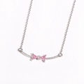 Macro view of pink zircon bow pendant with white micro-pave diamonds on silver chain - Style 2 White Gold (Pink Zirconia)