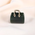 Macro view of a dark green gemstone mini handbag pendant with a golden metal handle - India Agate