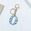 Golden keychain featuring letter O with vibrant peacock feather pattern on white background - Letter O (No Tassel)