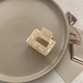 Detailed close-up of marble pattern square hair claw clip on a ceramic tray - Small Square Claw / Beige