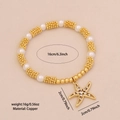 Pulsera de estrella de mar dorada con perlas blancas y circonitas sobre cobre - Estrella de mar
