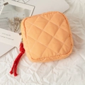 Detailed shot of quilted striped makeup bag with yellow zipper and red pull cord - Orange Check