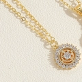 Detailopname van gouden O-ketting met een ronde hanger ingelegd met heldere zirkonia - Kompas Zirconia Stijl