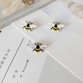 Close-up of three cute yellow honey bee enamel pins on a stylish background - Bee