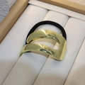 Coletero minimalista con brazalete de metal dorado en bandeja de exhibición blanca - Estilo C-Arco Liso