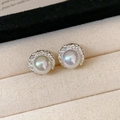 Primer plano de pendientes de mariposa vintage con perlas en bandeja de terciopelo - Pendientes de plata de ley 925 - Pendientes de botón de luna creciente plisada de perla color AB