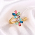 Primer plano de anillo de flor con cristales coloridos sobre elegante fondo de seda blanca - Estilo Flor Talla Pera Multicolor (Estilo 1)