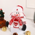 Pupazzo di neve natalizio in maglia su espositore festivo con decorazioni e pigne - Pupazzo di Neve