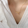 Elegant gold titanium bamboo branch necklace with leaf pendant worn by a female model - 40+5cm / Gold