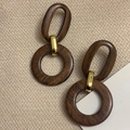 Détail des boucles d'oreilles œil de tigre en résine et anneaux dorés sur tissu beige - 28# Anneau Géométrique en Bois Ovale (Tige en Argent)