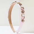Detailed view of pink satin headband with inlaid pearls and gemstones in gold metal frames - Pink