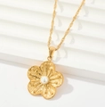 Close-up of golden flower pendant with pearl inlay on a white minimalist geometric base - Flower Pearl