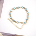 Dettaglio macro del bracciale dorato Evil Eye con ciondoli blu e zirconi brillanti - Blu