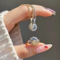 Schmuckset aus Gold mit Sonne-Mond-Motiv und blauen Zirkonia in eleganter Handansicht - Sonne und Mond Schmuckset (8859)