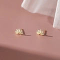 Elegante goldene S999 Silber Lotusblumen-Ohrstecker auf zartrosa Hintergrund - 990 Silber / Gold