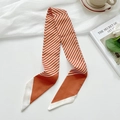 Elegant orange and white striped silk hair scarf tied on a white decorative background - Orange Fine Lines