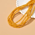 Detailed view of yellow irregular 4mm natural shell spacer beads on a white tray - 5# Yellow 4mm (1 Strand)