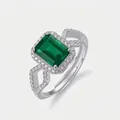 Detailed macro view of an adjustable silver ring with emerald cut green gemstone and diamonds - Emerald Green Ring (Silver V)