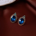 Dettaglio di orecchini vintage con pietre blu su uno sfondo di lussuosa seta rossa - Orecchini (Perno in Argento Sterling 925) / Oro/Blu Scuro