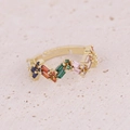 Primer plano de anillo ondulado dorado con circonitas de colores sobre piedra natural - Gema Colorida Rectangular Ondulada (3#)