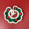 Close-up of green and white hand-knitted Christmas pet collar with red decorative pom-poms - S / Green