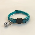Close-up of teal glitter cat collar with a silver bell and cat-head shaped safety buckle - Turquoise Green