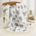 Detail of baby cotton gauze blanket featuring dinosaur prints and tassel fringe edges - Dinosaur