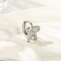 Pendiente de plata con diseño de lazo y circonitas sobre fondo de seda blanca - Earcuff de Lazo (Pieza Única)