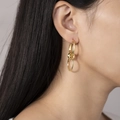 Elegant gold titanium steel triple hoop drop earrings shown on a female model profile - Three-Ring Interlocking Drop Earrings (E389-GO)