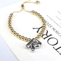 Detailed shot of golden bead bracelet with silver balloon letter R charm and adjustable clasp - Letter R