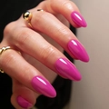Glänzende magentafarbene Mandel-Kunstnägel mit Spiegel-Finish auf einer Modellhand - Kleber-Typ / Drachenfrucht-Magenta