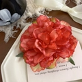 Pince à cheveux pivoine en tissu de soie dégradé orange-rouge sur une assiette en céramique - Marbre Rouge