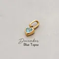 Golden heart-shaped pendant with blue topaz stone representing December birthstone - December Heart Pendant - Gold