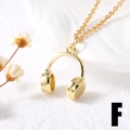 Detailed close-up of a 3D gold-plated headphone pendant on a delicate chain necklace - F-Headphone Shape