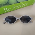 Macro shot of grey oval sunglasses with black lenses and white model specs on the temple - Premium Grey