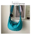 Detail of turquoise crescent crossbody bag with adjustable strap and plush charm - Soot Sprite Charm Style / Blue