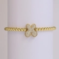 Golden beaded bracelet with a 18k sparkling zircon clover charm on a white stand - Letter X