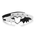 Detail of bat wings choker with silver heart ring on a polished white surface - Black and White Patchwork