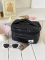 Grande borsa da trucco trapuntata nera con manico ed etichetta Soda Blue su tavolo - Nero