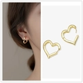 Elegant gold heart-shaped hoop earrings with polished finish shown on a female model - Gold Heart Buckle