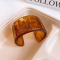 Detailed view of amber resin cuff bracelet with marble texture in eco-friendly tray - 38# Medium Width Open Cuff (38# Bangle - Coffee Color)