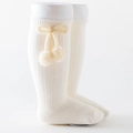 Ribbed knee-high baby socks in creamy white featuring decorative bows and soft pom-poms - Off-white