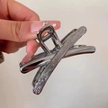 Silver liquid metal butterfly hair claw clip with textured finish held in hand - Crisscross Streamline / Black