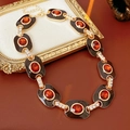 Detail view of vintage enamel gold necklace with red gemstones on brown leather - Brown Necklace