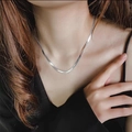 Minimalistische silberne Schlangenkette, von einem Model auf schwarzem Outfit getragen - H45 Flache Schlangen-Silberkette (40+5cm)