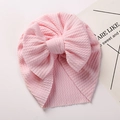 Detailed view of the pink ribbed fabric texture and large bow on this soft baby turban - Light Pink